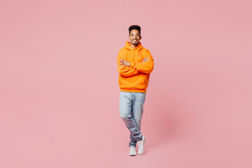 Fototapeta na wymiar Full body young man of African American ethnicity he wears yellow hoody casual clothes hold hands crossed folded look camera isolated on plain pastel light pink background studio. Lifestyle concept.