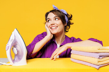 Close up young minded woman wear purple shirt casual do housework tidy up ironing clean clothes on...