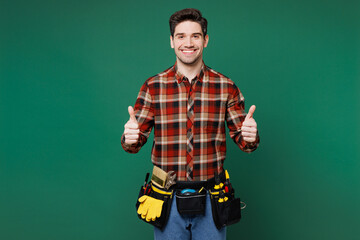 Young fun happy employee laborer handyman man wear red shirt look aside on area mock up isolated on plain green background. Instruments accessories for renovation apartment room. Repair home concept.