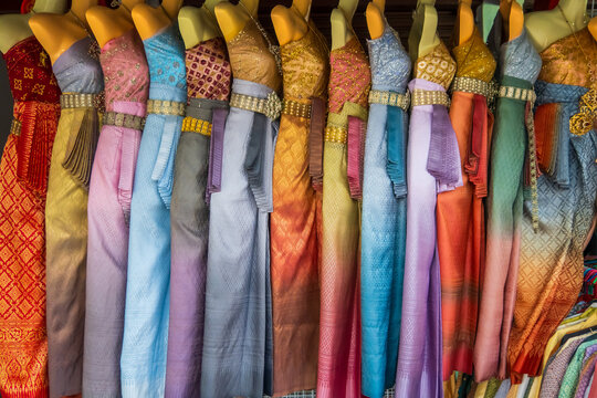 Row of traditional Thai women costumes up for sale at store.
