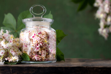 Horse chestnut flowers in a glass jar. Production of medicines, tablets, tinctures.