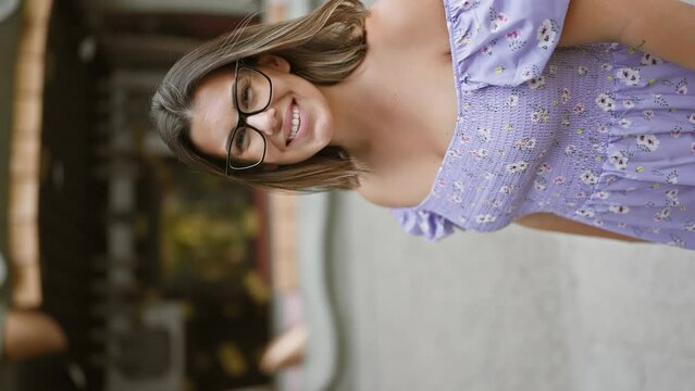 Cheerful beautiful hispanic woman with glasses poses with confident, joyful smile at namba yasaka jinja in osaka, standing by the impressive giant dragon statue.