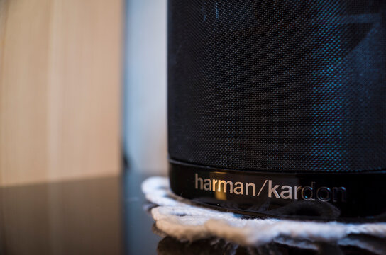 V&auml;ster&aring;s, Sweden - February 7, 2024: Harman Kardon speaker close up photo of brand name, black music speaker stands on a white knitted napkin at home, photo with selective focus