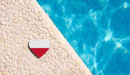 Poland flag in the shape of a heart near the pool in the hotel. Holiday concept in Polish hotels
