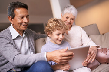 Happy family, grandparents and little boy with tablet for entertainment, social media or research on sofa at home. Grandma, grandpa and child smile on technology for online search or movie at house