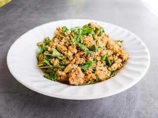 Northern Thai style spicy roast minced pork with thai herb or Larb Moo on white dish on dark table. ....