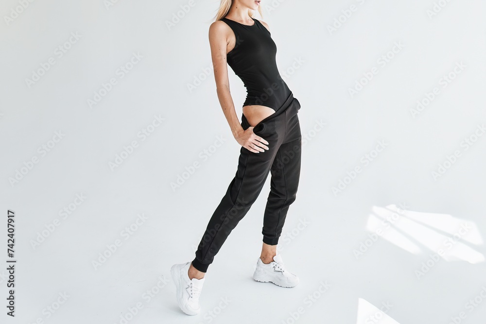 Canvas Prints Well-shaped Athletic Young Woman wears Versatile Dark Trousers in Studio