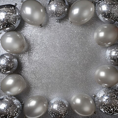 Glittering silver background with silver balloons around the border 