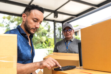 Man signing to pick up delivering parcel from courier man 