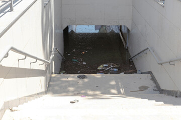 The pedestrian underpass is flooded with muddy water after the storm.