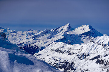 Naklejka premium Scenic view of mountain panorama with snow covered mountain peaks in the Swiss Alps at mount Titlis on a sunny winter day. Photo taken February 21st, 2024, Titlis, Engelberg, Switzerland.