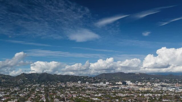 Aerial view of city of Los Angeles cityscape. Hyperlapse zoom in on beautiful clouds rolling over Hollywood Hills.