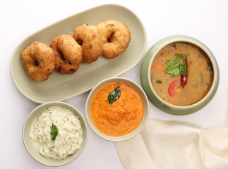 Vada / Medu vadai with sambar - Popular South Indian snack served on a steel serving plate, selective focus