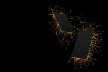 Two black blank bank cards or greeting card mockup for branding text or advertising, design flying in golden light sparkle with burning flashes of firework on black background as Chinese New Year.
