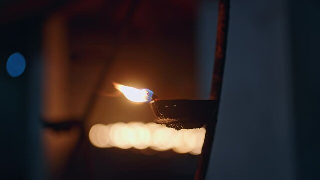 Traditional oil lamps burn softly in serene Buddhist temple. Flickering flames create tranquil atmosphere. Devotees meditate, seeking spiritual enlightenment. Holy site glows at dusk, inviting peace.