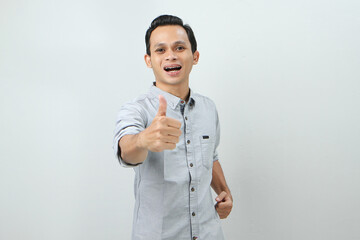 cheerful happy confident asian indonesian man with thumb up finger gesture on isolated background