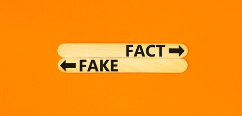 Fact or fake symbol. Concept word Fake and Fact on beautiful wooden stick. Beautiful orange table...