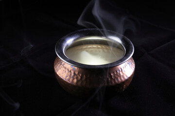 Brass copper metal style pot cauldron smoke vape fog lit inside rising flowing moving rotate on black background - 742448793