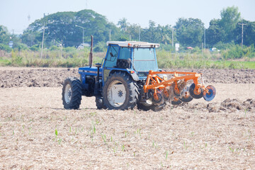 Farmers drive tractors to plow the soil for farming.