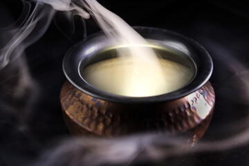 Brass copper metal style pot cauldron smoke vape fog lit inside rising flowing moving rotate on black background - 742451376