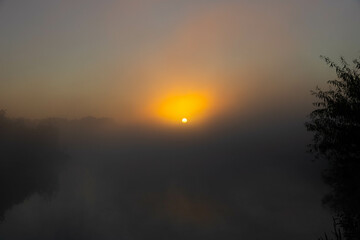 Panorama of beautiful misty lake coast at sunrise moment.