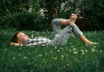 little boy sitting on the grass