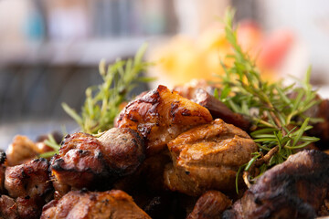 Delicious grilled pieces of meat on the grill lie on a plate decorated with herbs. Selective focus.