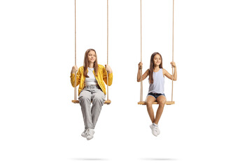 Two sisters sitting on wooden swings