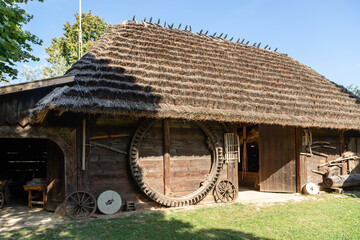 Stary drewniany budynek z dachem pokrytym strzechą budowany na dawnej polskiej wsi