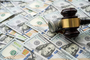 Gavel above piles of new 100 dollars bills as finance background.  Justice concept