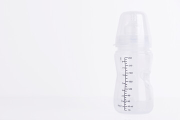 Baby feeding bottle with pacifier on a white background. Copy space.