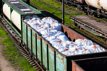 Transportation of fertilizers in huge bags and wagons by rail. Fertilizer cars, freight train.