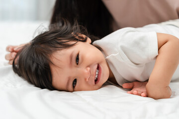 happy toddler baby lying on bed