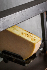 A piece of cheese being melted on a machine.