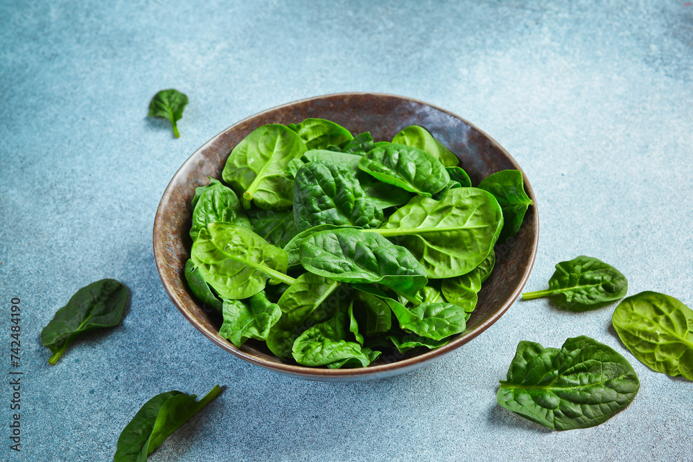 Wall mural fresh green spinach in a ceramic plate. healthy food concept. space for text.