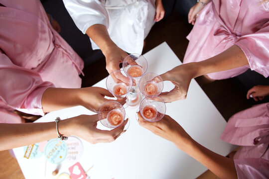 Despedida de soltera. Novias brindando en la despedida de soltera. Fiesta de albornoces. Novia y damas de honor. Champ&aacute;n. Cenital.