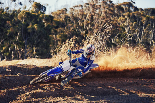 Person, professional motorcyclist and dirt track for competition, extreme sports or outdoor race. Expert rider on motorbike or scrambler for sand course, challenge or off road rally track in nature