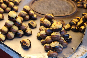 Chestnuts inside a cone with the fireplace in the background. Making roasted chestnuts at home