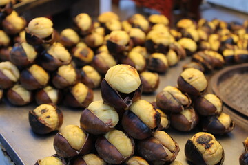 Chestnuts inside a cone with the fireplace in the background. Making roasted chestnuts at home