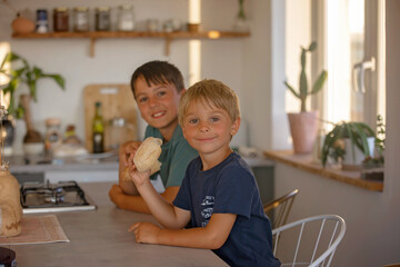 Cute blond child, boy, eating soup at home for dinner, summertime