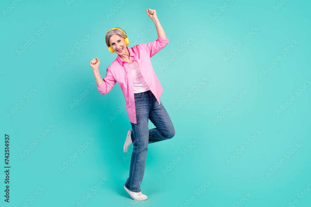 Wall mural full length photo of satisfied retired woman stand one leg in headphones dancing raising hands up is