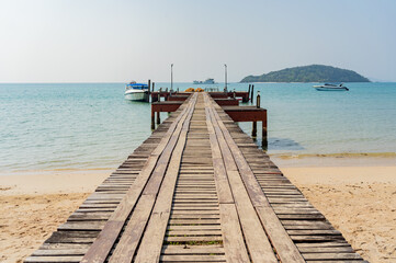 Fototapeta premium A wooden harbor bridge that stretches into the sea. On Koh Mak, Trat Province, Thailand
