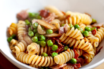 Pasta and peas and ham on a white plate - 742525368