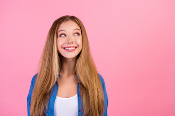 Photo of cheerful dreamy lady dressed blue shirt looking empty space isolated pink color background