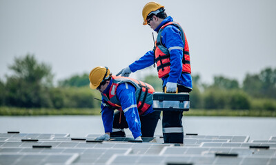 Obraz premium Engineers inspect the structural stability and alignment of floating solar panel arrays as QC work.