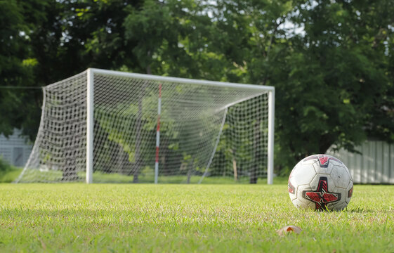An old soccer ball lay on the grass , which ideal for use in the design put images and insert text.