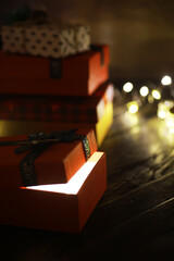 Gift boxes against a background bokeh of twinkling party lights. Luxury New Year gift. Christmas gift. Christmas background with gift box. Christmastime celebration