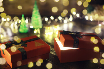 Gift boxes against a background bokeh of twinkling party lights. Luxury New Year gift. Christmas...