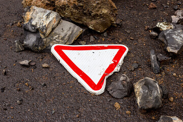 Road sign broken, fell to the ground, rockslide.