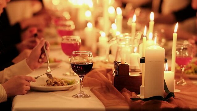 Banquet, Festive Dinner By Candlelight In A Restaurant. People Sit At A Dinner Table With Side Dishes And Drinks.